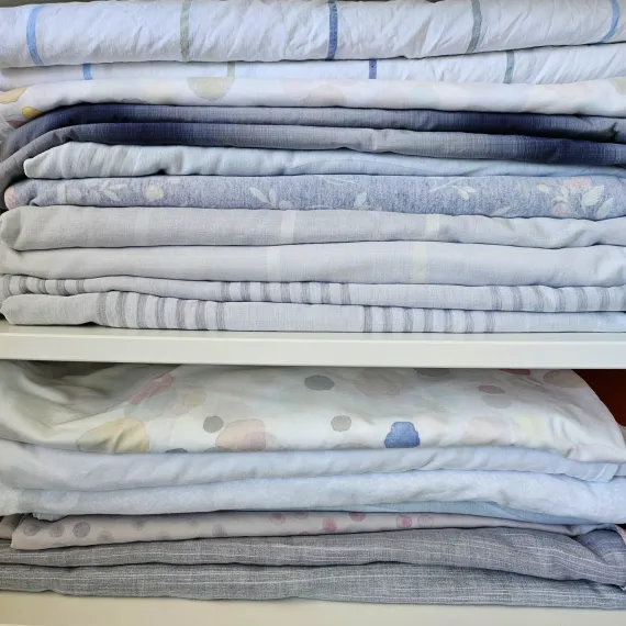 Stapel frisch gewaschener Bettwäsche im Schrank