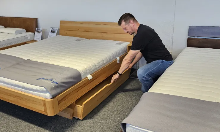 Junger Mann probiert Schublade von Stauraumbett aus