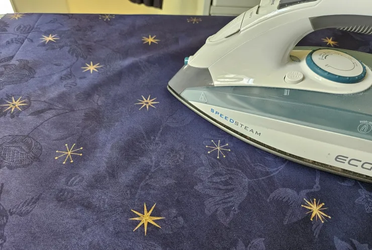 Bügeleisen auf blauer Bettwäsche